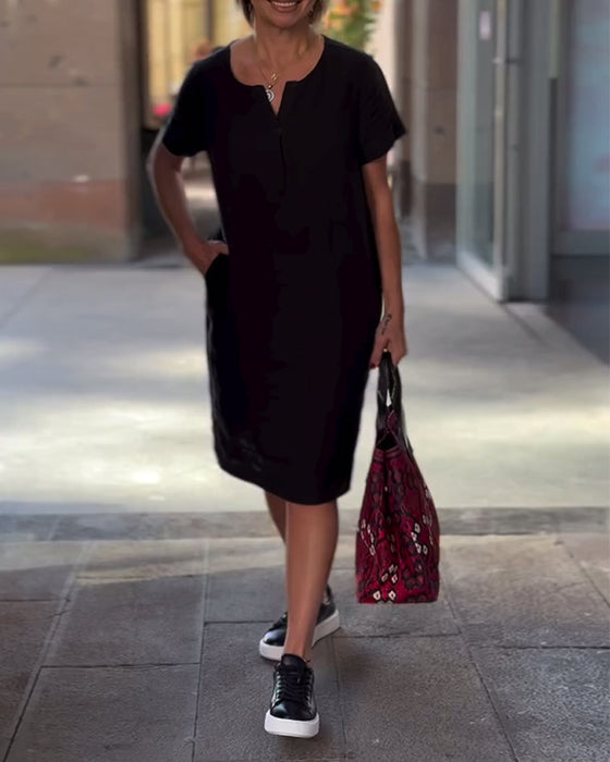 Enfärgad fickklänning med V-ringning och kort ärm