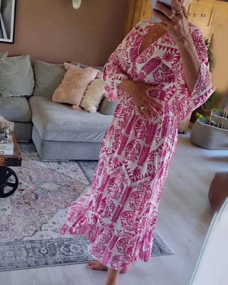 Elegant tryckt klänning med V-ringad veck och bell-sleeve