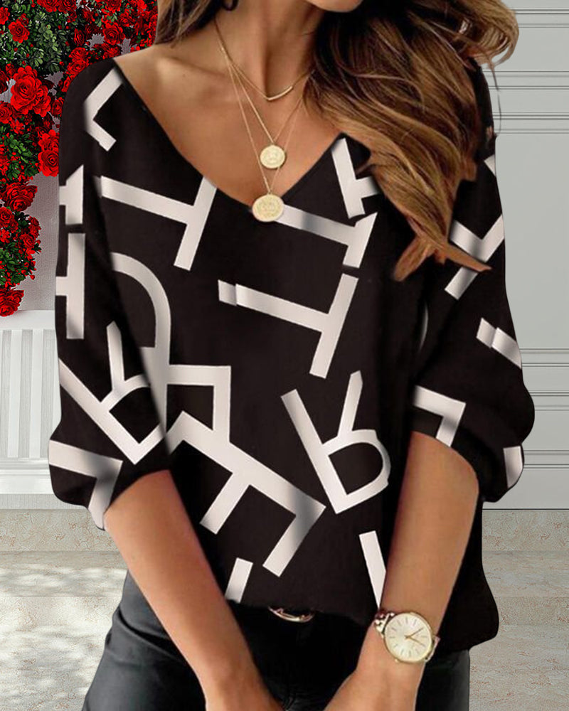 Långärmad topp med bokstavs- och fjädertryck