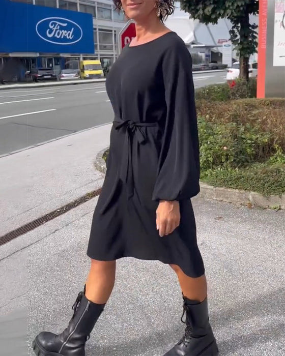 Enfärgad klänning med rund hals och knytband