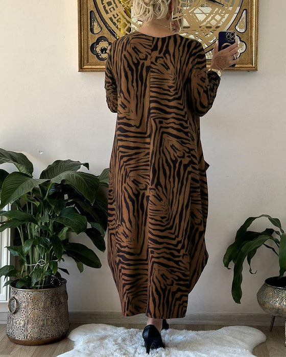 Lös modeklänning med tryck och fickor