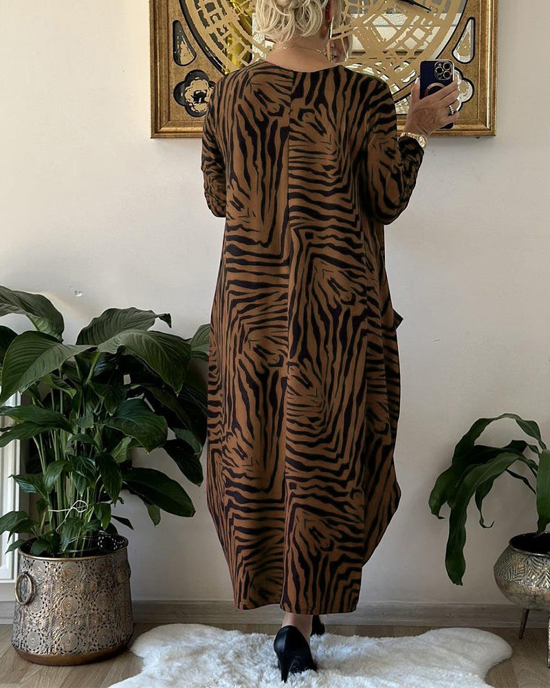 Lös modeklänning med tryck och fickor