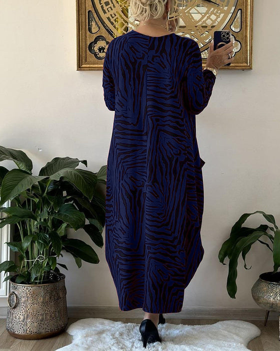 Lös modeklänning med tryck och fickor