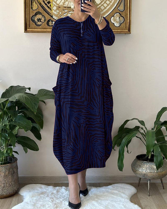 Lös modeklänning med tryck och fickor