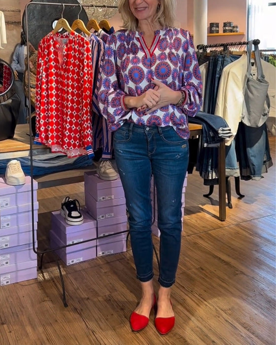 Elegant v-ringad blus med geometriskt tryck