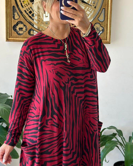 Lös modeklänning med tryck och fickor