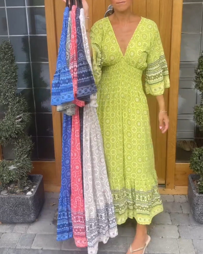 Lång klänning med djup V-ringning och utsvängd ärm