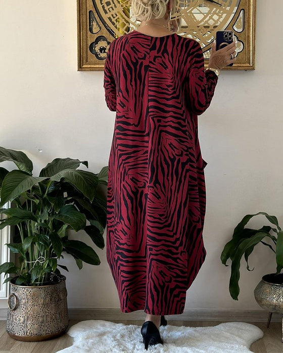 Lös modeklänning med tryck och fickor