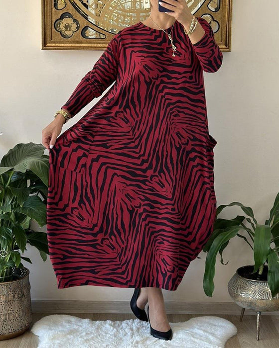 Lös modeklänning med tryck och fickor