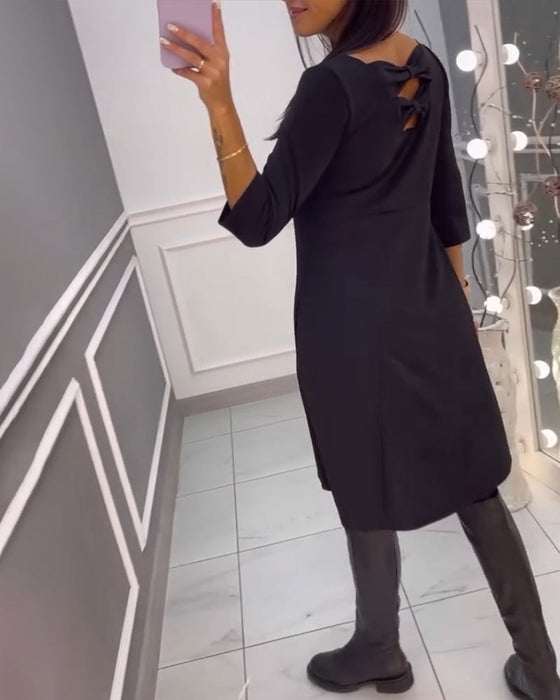 Enfärgad klänning med rosett rygg